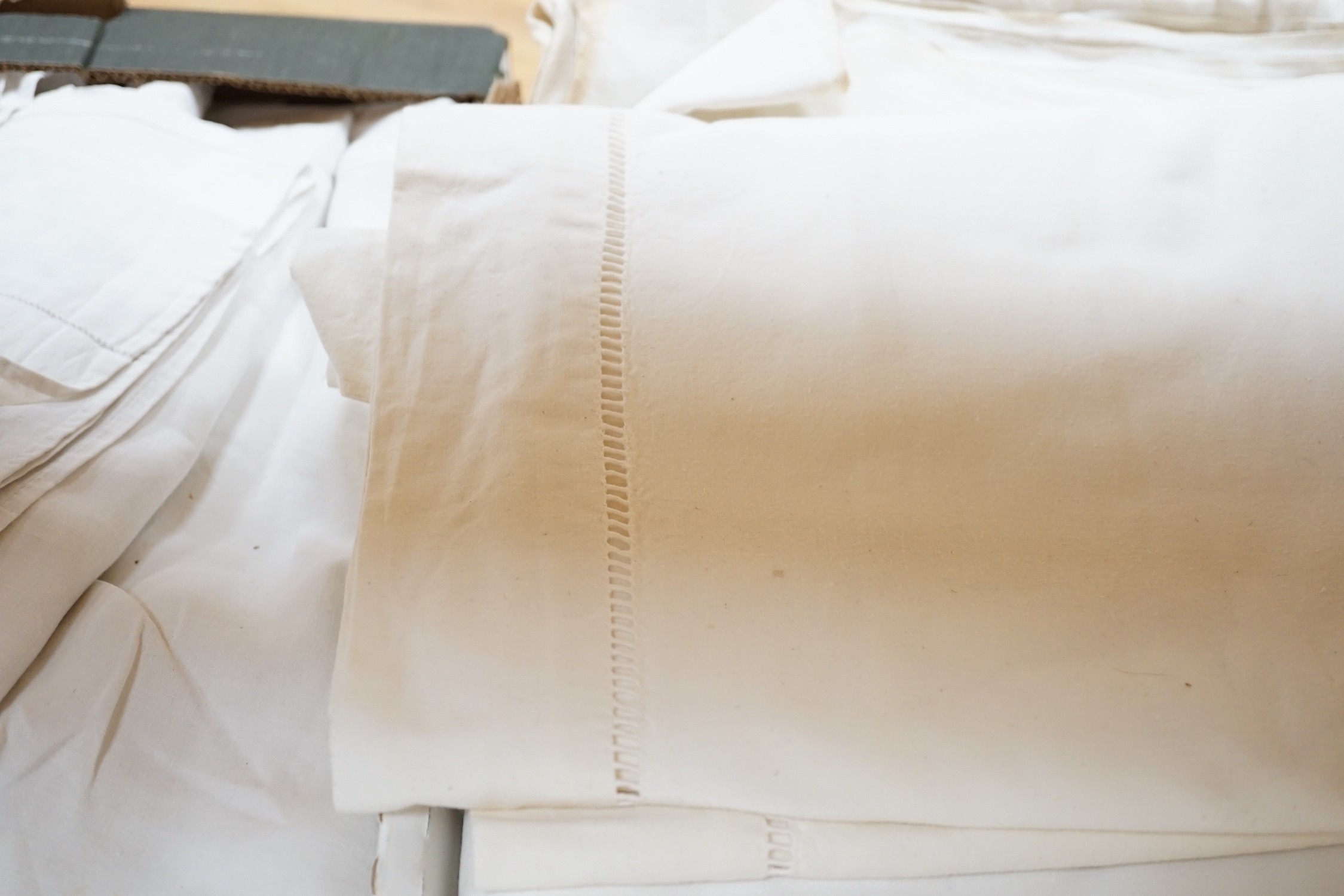 A quantity of French provincial linen sheets, some with monograms and button holed turn back